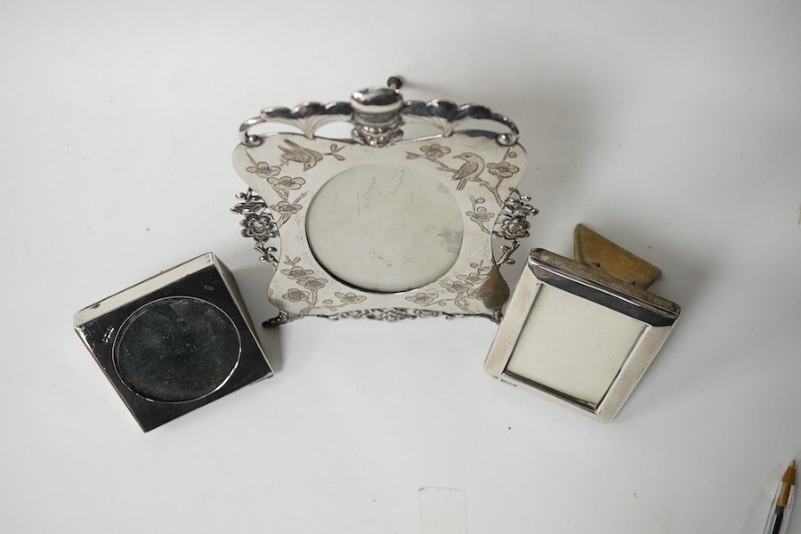 A Chinese Export engraved and embossed white metal photograph frame, maker KW, 14.5cm, together with two small Edwardian silver mounted photograph frames. Condition - fair to good